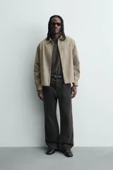 Sobrecamisa boxy fit de hombre confeccionada en tejido efecto ante color beige, con cuello solapa, manga larga con puño abotonado, bolsillo de parche en el pecho y cierre frontal con botones a presión ocultos.