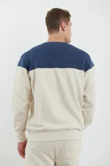 Sweater deportivo de hombre con escote redondo, diseño colorblock con la parte superior en gris claro y el cuerpo y mangas en negro. Presenta puños y cintura elastizados.