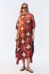Kaftan maxi amplio de color amarillo, con escote redondo, mangas cortas y ruedo irregular. Presenta un diseño estampado a cuadros con efecto teñido.