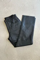 Pantalón de cuero negro, de corte recto y tiro medio.