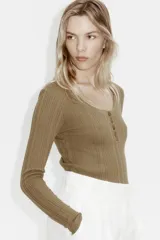 Top de manga larga en punto acanalado de algodón con diseño pointelle, escote en U con ribete festoneado y tapeta con botones frontales.