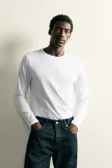Camiseta slim fit de manga larga y cuello redondo, confeccionada en tejido de algodón elastizado de color marrón oscuro.
