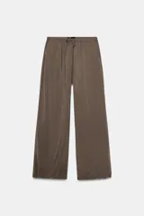 Pantalón fluido color marrón, de tiro medio, con cintura elástica y cordón ajustable. Tiene bolsillos delanteros y bajo ajustable con cordones.