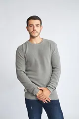 Sweater de punto color mostaza, con cuello redondo y mangas largas.