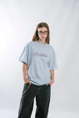 Remera de manga corta, corte oversize, color celeste claro, con la palabra "Superstar" bordada en el pecho en tipografía cursiva con contorno negro.