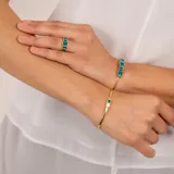 Brazalete abierto dorado en plata 925 bañada en oro de 18k con piedras topacio azul y jade verde.