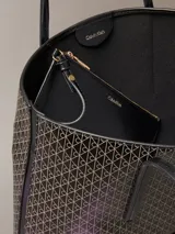 Cartera tote pequeña de Calvin Klein con estampado de monograma CK en color negro, asas de hombro dobles e incluye una cartera mini lisa a juego en el interior.