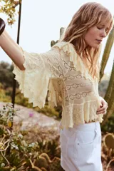 Falda pantalón corta de tiro alto color blanco, con bolsillos delanteros y traseros. Cierre frontal cruzado con cremallera oculta y botón metálico.