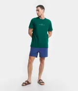 Remera de corte comfort color verde, con cuello redondo y manga corta. Presenta un pequeño estampado minimalista en el centro del pecho con la inscripción 'Nautique des Regates'.