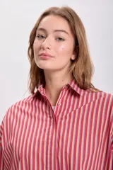 Camisa de manga larga con cuello clásico y cierre con botones, con estampado de rayas verticales rojas y amarillas.