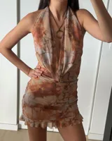Minivestido marrón con estampado abstracto, escote halter y volados en el ruedo.
