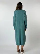 Vestido midi de punto color tostado, con cuello alto, manga larga y bolsillo lateral.