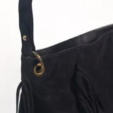 Cartera de hombro color negro, confeccionada en gamuza, con diseño decorado con flecos largos en los laterales y el frente. Incluye una correa larga extraíble y ajustable.