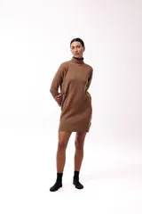 Vestido corto de tejido de punto color marrón, con cuello alto y mangas largas. Presenta un diseño de silueta relajada y terminaciones acanaladas en puños y ruedo.