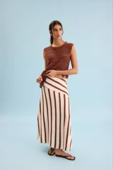 Pollera larga de punto en color beige con rayas verticales marrones, corte evasé y diseño asimétrico en la cintura.