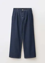 Pantalón de jean estilo wide leg en color azul oscuro, con tiro medio, detalle de pinzas en la cintura, cierre frontal con cremallera y botón, y bolsillos laterales.