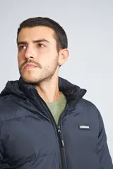 Campera puffer azul marino para hombre, con capucha desmontable, cierre frontal completo, bolsillos con cierre y logo de goma en el pecho.