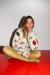 Sweater tejido a mano con lana merino color crema, de corte holgado y cuello redondo. Presenta bordados de motivos de picada: aceitunas, tomates, pretzels, queso y pescado.