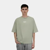 Remera de corte oversize color verde, con estampa gráfica en la espalda que incluye el logo de la marca y un diseño de globo terráqueo.