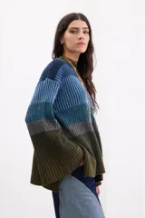 Sweater de tejido de punto con diseño de bloques de colores en degradé que van desde el azul en la parte superior hasta el verde militar en la parte inferior. Tiene cuello redondo y mangas largas amplias con tajos.