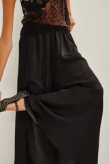 Pantalon de corte amplio y tiro alto, confeccionado en tejido fluido de viscosa y modal, con cintura elástica.