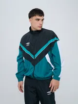 Campera de nylon Umbro con bloques de color en negro, verde oscuro y blanco, de cuello alto y cierre frontal completo.