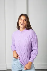 Sweater de punto color lila, con cuello redondo y diseño trenzado en relieve. Presenta mangas largas con puños acanalados y un corte holgado.