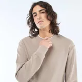Sweater de tejido nido de abeja color beige, con cuello redondo, mangas largas y puños elastizados acanalados.