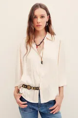Camisa de poliéster color azul, de corte holgado, con mangas largas y puños elásticos.