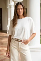 Remera negra de corte oversize, con cuello redondo y mangas cortas de caída fluida. Presenta un diseño minimalista con aberturas laterales en el ruedo.