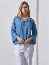 Blusa celeste de lyocell con cuello a la base y escote en V con lazo de ajuste. Manga larga amplia.