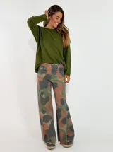 Pantalon de denim con diseño de camuflaje en tonos verde, gris y marrón. Presenta un corte recto y amplio, con terminaciones deshilachadas en el ruedo.