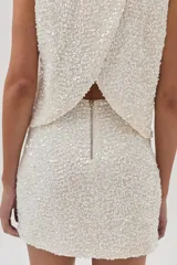 Minifalda de lentejuelas color blanco sobre base de terciopelo ligero.