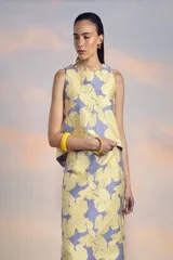 Top sin mangas color lila con estampado de flores amarillas.