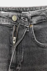 Jeans de tiro alto color marrón oscuro con acabado lavado, corte recto/flare y bajo cropped sin costuras. Presenta cinco bolsillos y cierre frontal con cremallera y botón metálico.