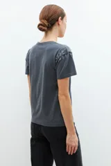Remera gris oscuro de manga corta, con escote en V y aplicación de tachas plateadas en los hombros.