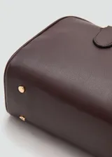 Bolso de mano de poliuretano color marrón oscuro, con doble asa para el hombro, herrajes metálicos dorados y detalle de llavero decorativo con candado y llaves.