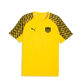 Camiseta de fútbol Puma del Club Atlético Peñarol, modelo Team Liga. Diseño en color amarillo con mangas raglán que presentan un patrón gráfico geométrico en negro y amarillo. Incluye el logo de Puma y el escudo del club en el frente.