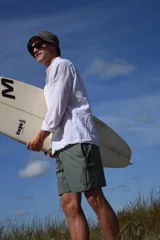 Short de baño verde con estampado de hojas y flores en tonos verde oscuro y marrón. Tiene bolsillos laterales y traseros, cintura elástica con cordón ajustable y corte clásico.