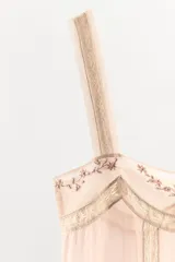 Top de tirantes anchos con escote recto, confeccionado en viscosa. Presenta detalles de bordados con aplicación de abalorios y encaje a contraste en el escote y el ruedo.