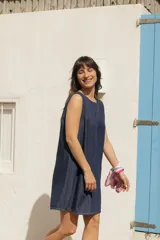 Vestido corto de denim liviano, de silueta evasé y calce relajado, sin mangas, con escote redondo y detalle de lazos en la espalda.