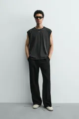 Camiseta tank gris con efecto lavado, de corte relajado, cuello redondo y manga raglán sisa.