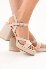 Sandalias de taco ancho y plataforma, color arena, con tiras cruzadas en el empeine y tira ajustable con hebilla en el tobillo.