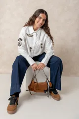 Pantalón de jean azul de corte ancho y tiro alto, con diseño de cinco bolsillos y costuras a la vista.