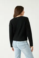 Sweater color beige de tejido de punto acanalado, con escote en V y corte ligeramente holgado.