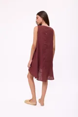 Vestido corto sin mangas color marrón chocolate, con corte holgado tipo babydoll y un pequeño ojal en el centro del escote redondo. El ruedo tiene un volante sutil.