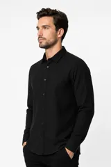 Camisa de viscosa color blanco, de corte holgado, con mangas largas, cuello clásico y cierre frontal de botones.