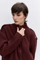 Cardigan de punto acanalado en color bordó, con cuello polo y cierre frontal de botones. Presenta un diseño de hombros caídos y mangas largas con puños ajustados.