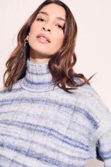 Polera celeste con rayas horizontales en tonos de azul y blanco, de cuello alto y corte oversize.