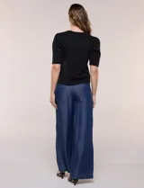 Remera de algodón negro, de silueta semi entallada, con escote redondo y mangas cortas abullonadas al codo con frunces en los hombros.
